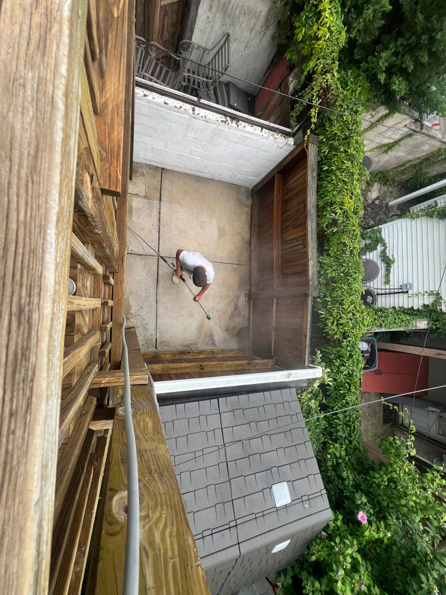 Ryan pressure washing a backyard patio from an overhead view